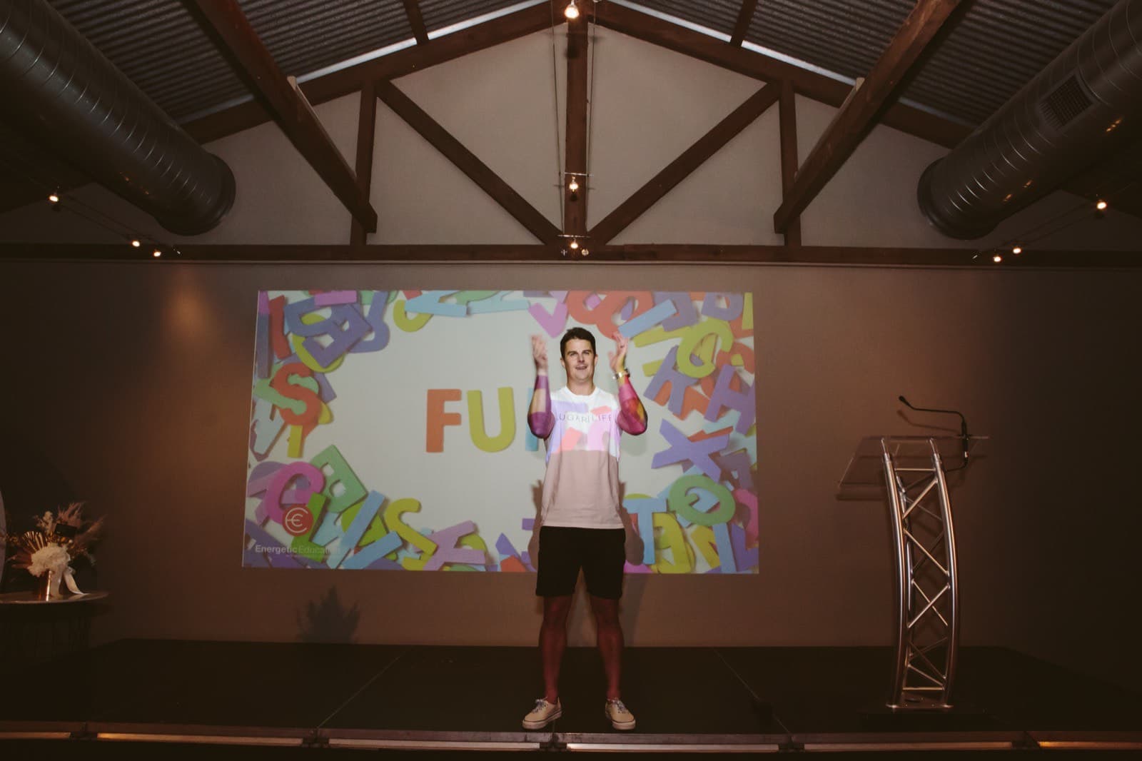 Dale Sidebottom speaking at the PHASE conference wearing a PLAY shirt